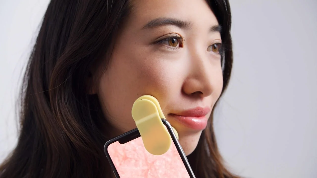 FitSkin scanner and phone showing a magnified skin image